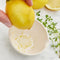 model zesting a lemon with cream colored peel, grate, and herb stem remover bowl 
