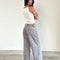 back view of model wearing light grey low rise wide leg denim and white tank