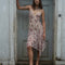 model wearing pink floral midi dress with layered hem, bow detail and v-neckline