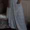 bottom view of model wearing white asymmetric maxi skirt with lace and embroidery detail