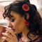 model wearing red large button earrings and matching hair clip