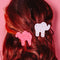 model wearing pink and white animal cookie hair clips with multicolor rhinestone details