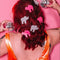 model wearing pink and white animal cookie hair clips with multicolor rhinestone details