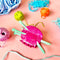 pink ball of yarn hair claw with two mint knitting needles sticking out.