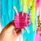 model holding pink ball of yarn hair claw with two mint knitting needles sticking out.