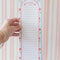 model holding light blue and white vertical stripe with cherry print and shopping list with lines