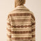 back view of model wearing cropped white zip up jacket with brown alpine print
