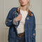 model wearing denim oversized jacket with corduroy collar, patch pockets, and embroidered star, moon and sun pattern