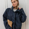 model wearing buttoned oversized high neck denim cropped jacket with tie drawstring hem