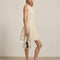 side view of model wearing cream lace mini dress with faux button front detail