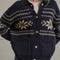 up close of model wearing navy oversized collared cardigan with white snowflake print and patch pockets