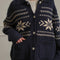 model wearing navy oversized collared cardigan with white snowflake print and patch pockets