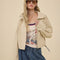 model wearing light khaki cropped jacket with stand up collar and elastic bottom