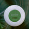 up close of forest green and white round attachable personal security alarm