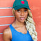 model wearing green dad hat with red tomato design