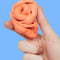 model holding clementine coral fidget putty