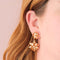model wearing gold double bow tiered dangle earrings