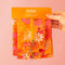model holding packaged set of three orange retro floral packing pouches