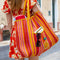 model carrying orange, yellow, and pink vertical stripe recycled plastic tote with ribbon detail and lemon applique