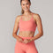 model wearing bright coral sports bra