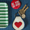 cream patch keychain with red heart and navy trim with a pin and tray