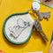moomin sitting keychain with moomin charm on a yellow book