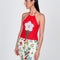 model wearing red knit halter top with white flower print on the front