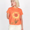model wearing orange cropped relaxed tee with realistic sunflower print