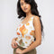 model wearing white tank with colorful seashell print and blue trim