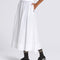 up close of model wearing white flowy midi skirt with black tank and vans sneakers