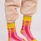 model wearing pink and red stripe socks with chartreuse trim