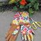 light blue arm saver gardening gloves with colorful floral print and brown textured design with matching buckle around the wrist on pavement