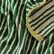 up close of green and cream vertical stripe terry cloth towel with lime green trim