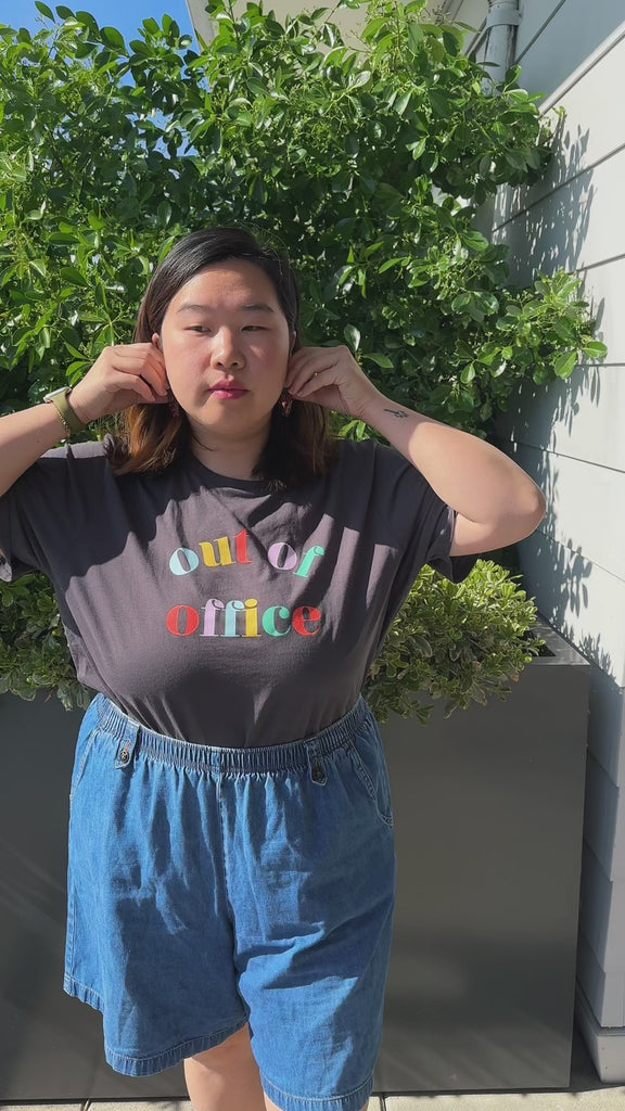 model wearing vintage black tee with colorful 'out of office' across the front
