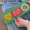 model puttingset of 3 embroidered patch stickers: yellow heart with green 'having the most fun possible' across the front, white round 'most likely to glue my fingers together' and red rectangular 'in friendship we trust' onto a denim jacket