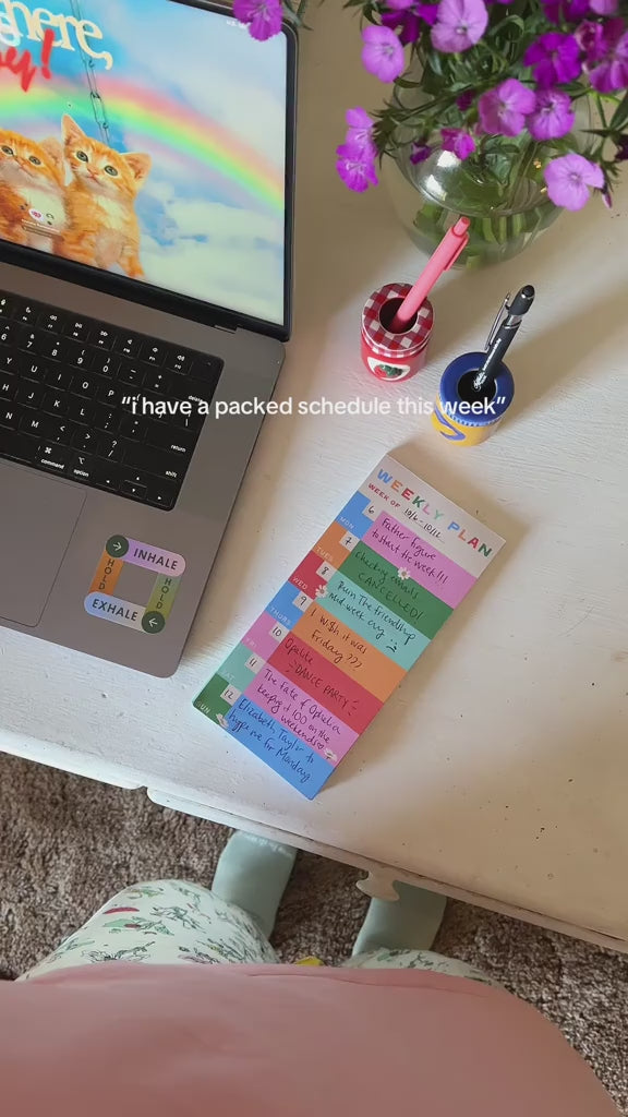 model writing their packed schedule on colorful weekly plan notepad