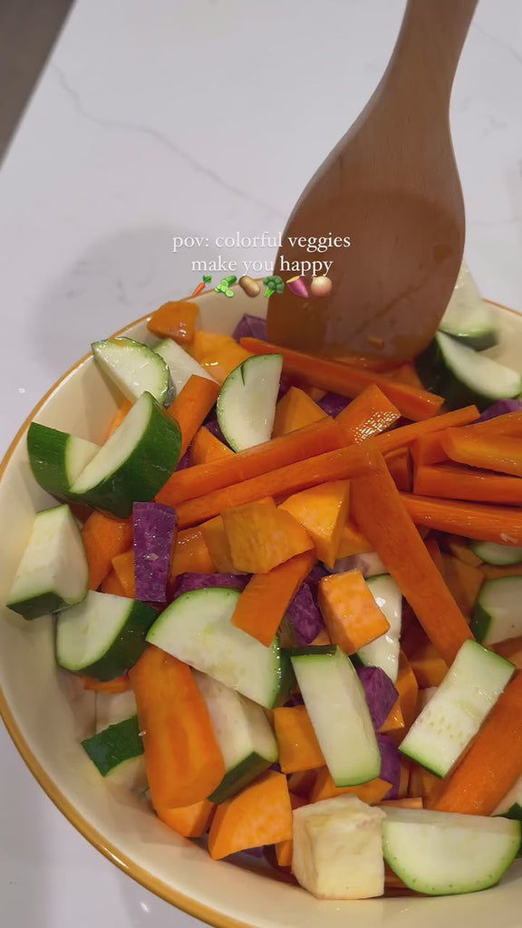 model making roasted veggies in red serving bowl with vintage banner