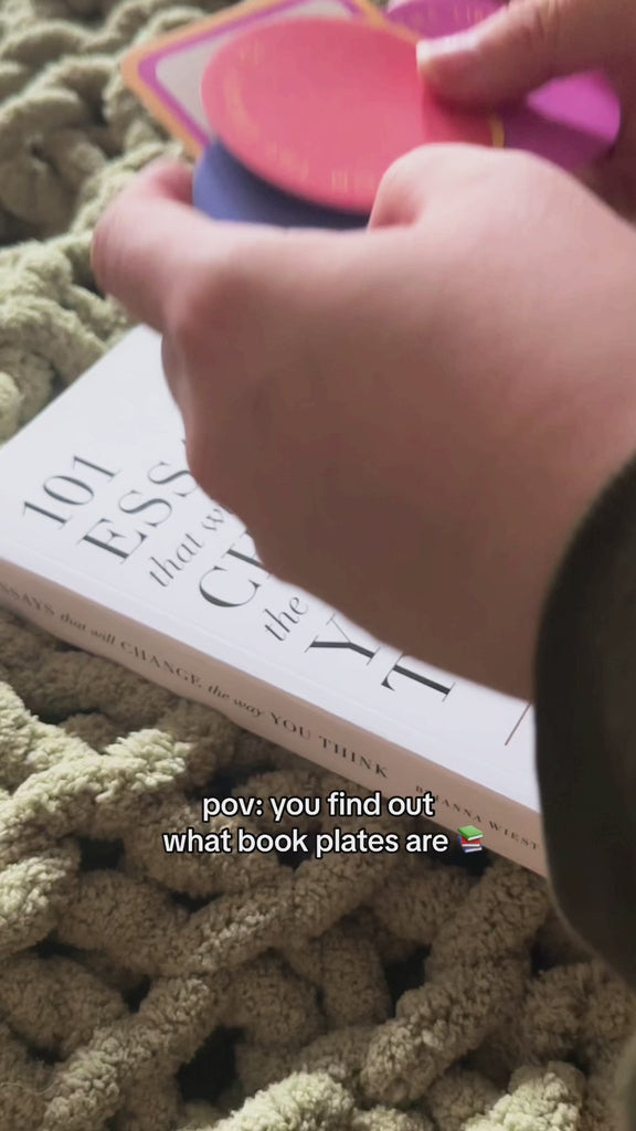 model putting  colorful circle and smiley square bookplates with 'from the library of" and 'this book belongs to' on a book