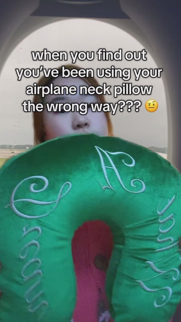 model showcasing green velvet travel pillow with white 'what a dream' with pink bow