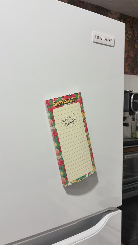 model writing notes on fruit themed shopping list pad