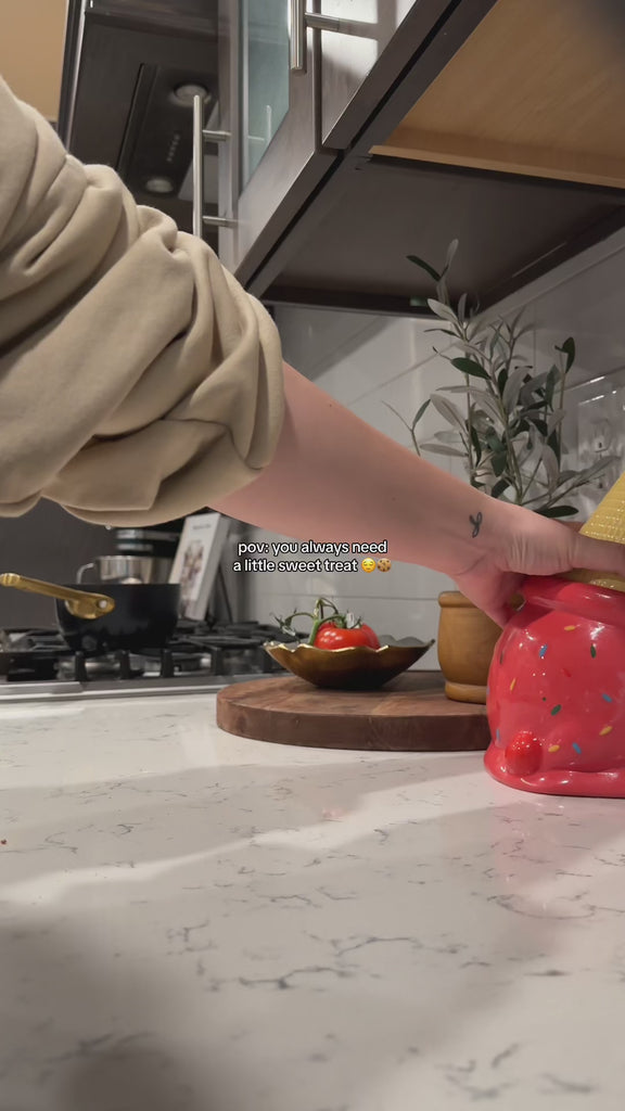 model pulling cookies out of pink ice cream cone shaped cookie jar