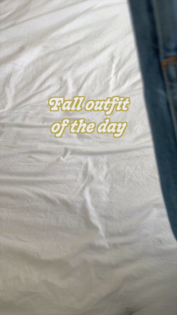 model wearing green sweater with a butterfly on the front