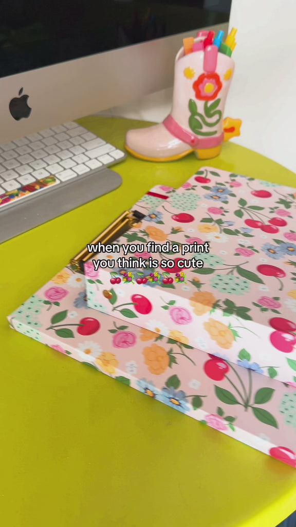 model showcasing light pink clipboard and binder with colorful floral and fruit print