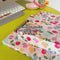 model showcasing light pink clipboard and binder with colorful floral and fruit print