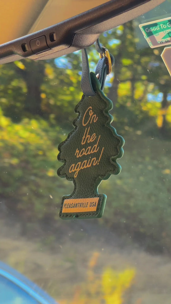 'on the road again' luggage tag hanging from their rearview mirror