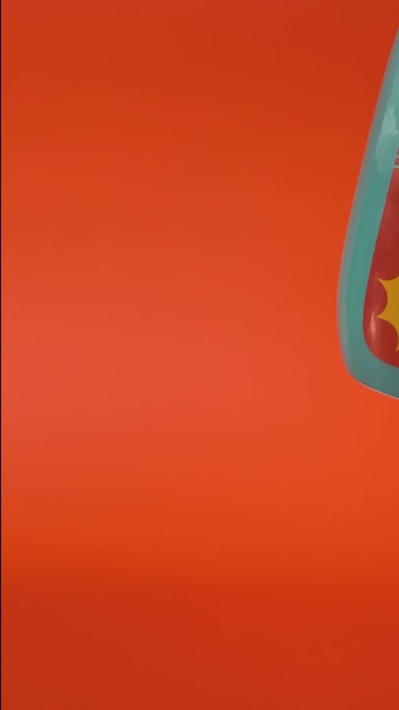 model showcasing teal ceramic vase with red and yellow 'sunblock 30 SPF' label and yellow flowers inside