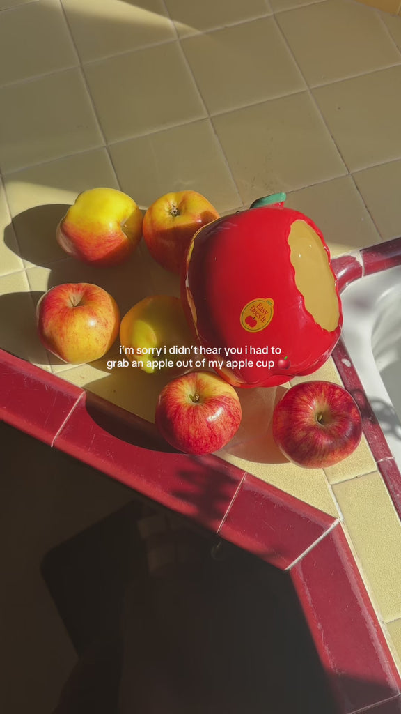 model putting an apple in red apple planter