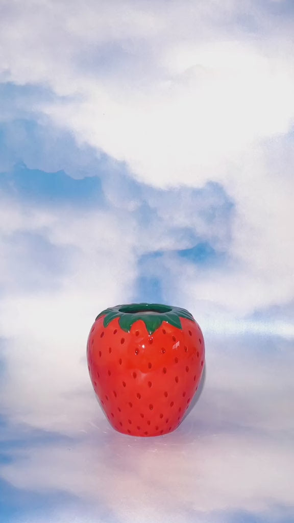 video of arranging purple flowers in the strawberry vase