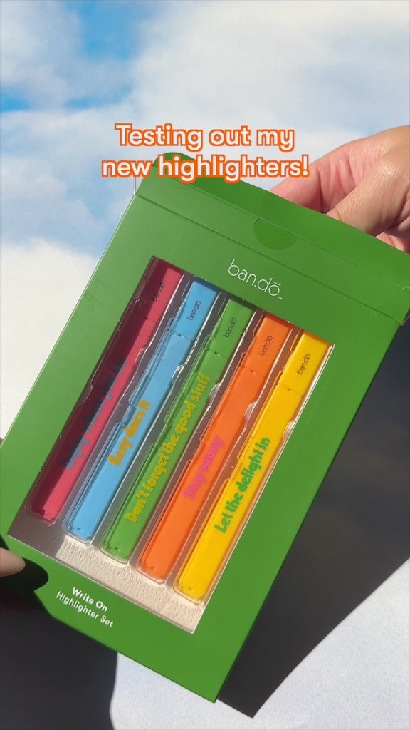 model using set of five neon highlighters with various positive sayings on them