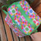 model pulling colorful cups out of colorful 'quilted' star lunch bag with green trim and strap and front pocket